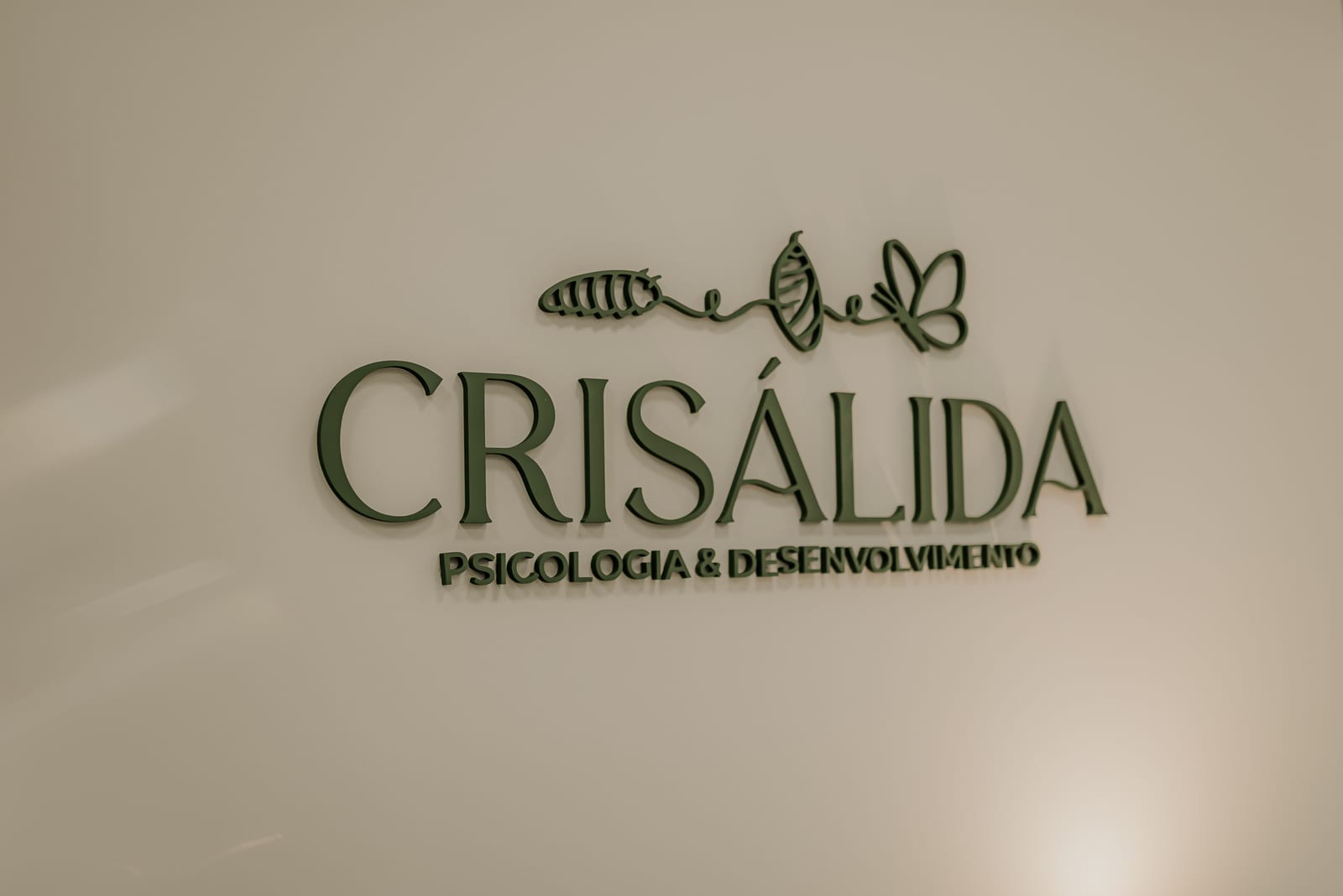 A marca Crisálida aplicada em relevo na parede do consultório
